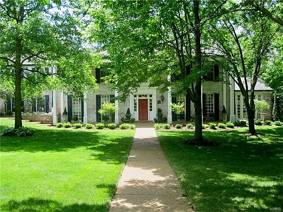 Elegant brick home nestled among mature landscaping on nearly 1 acre.