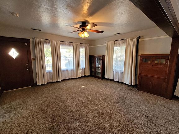 Living room with craftsman front door, built-in bookcases and large picture windows