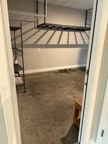 one car garage with ceiling rack shelving and storage shelves