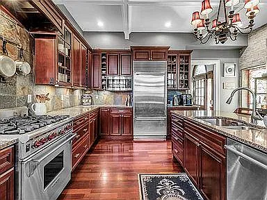 kitchen showing wolf stove, sink/island, subzero refrigerator and entrance into the dining room