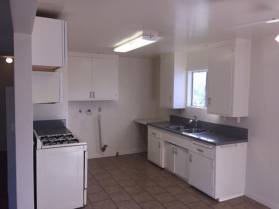 Kitchen showing Sink Area and Cabinets with Washer-Dryer Hook-ups and Range to the Left.