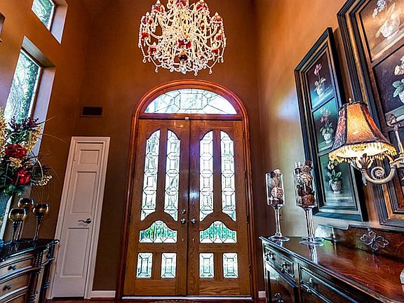 Enter this amazing home through oversized, cut glass double doors.  The transom window above the doors allows a lot of natural light into this stunning entry.