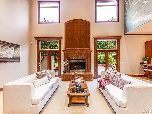 The spacious living room has tons of natural light, a gas fireplace, two entrances to the back patio, and if you look up, you'll notice a subtle yet beautiful hand painted mural. 