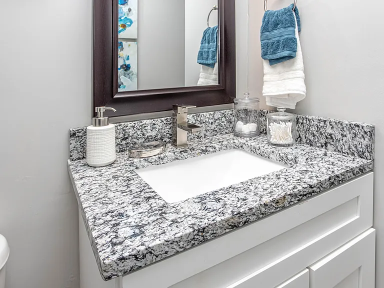 Bright bathroom with granite counters and bathtub