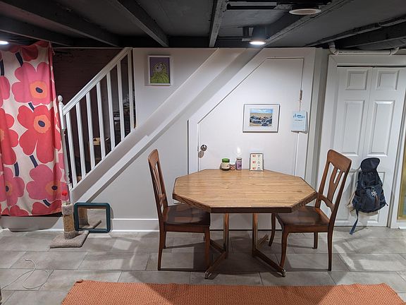 Dining area next to TV nook & living space. Stairs sealed off from the upstairs unit can be converted into storage space.