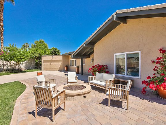 Front of house and 2 car garage and long driveway from gas grill area and gas firepit