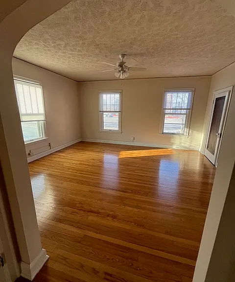 Living room looking from the hallway by bathroom, bedroom and kitchen