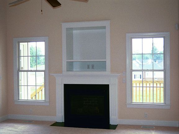 Family room with high ceilings, fireplace, and recessed television cabinet