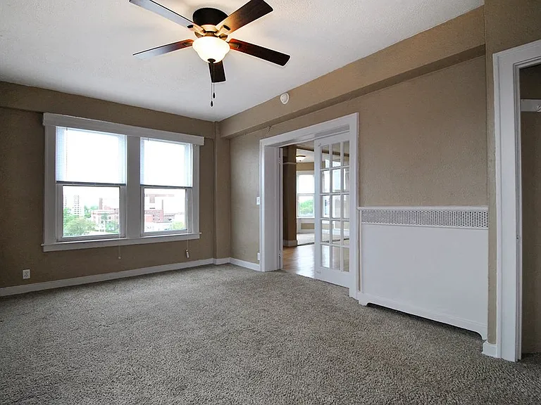 Bedroom with plush carpeting and double doors.