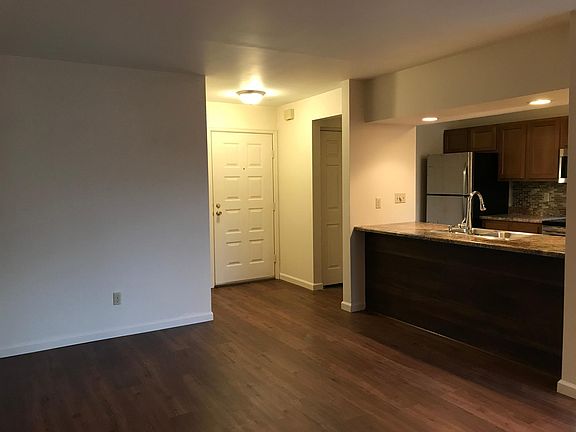 from corner by fireplace toward entryway and kitchen