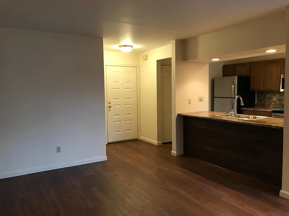 from corner by fireplace toward entryway and kitchen