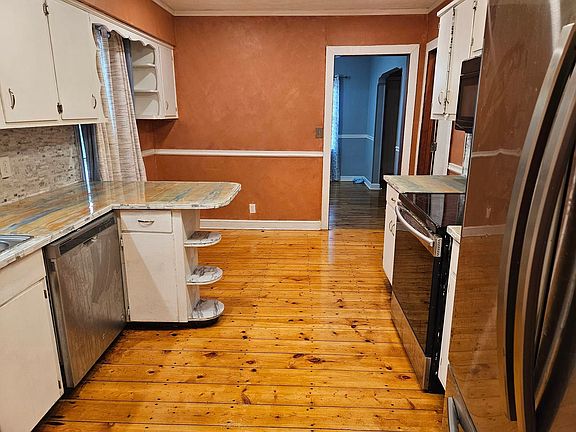Kitchen with all new stainless steel appliances, and eat in area that leads to a large dining room.