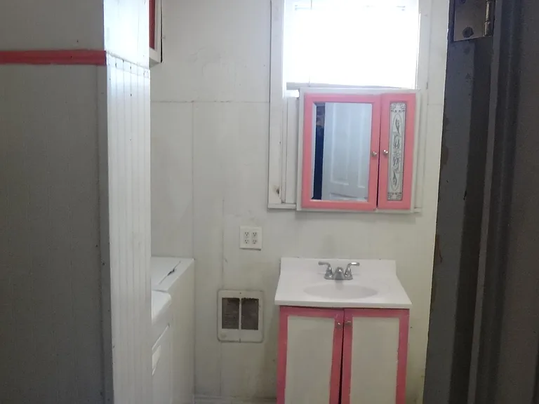 Bathroom has electric heater, lots of storage, shower with bath, vent fan for toilet, high ceiling, vice vanity.