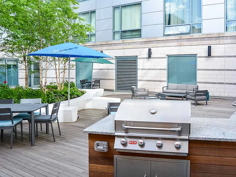 50 West Broadway's Courtyard with Lunch Tables & Grills