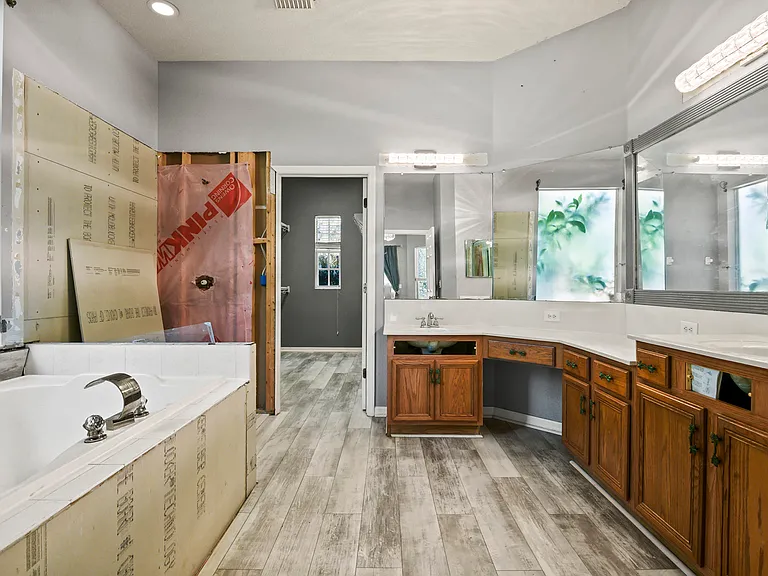Upgrade started. Master bath with 2 level counters and makeup vanity; needs shower finished and tip-out cabinet sink fronts replaced. Access to primary walk-in closet