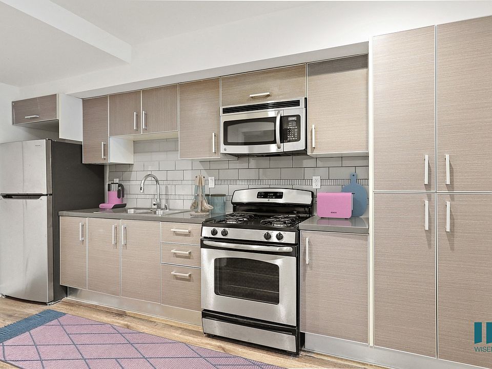 Open-Concept Kitchen with Stainless-Steel Refrigerator, Stove, and Microwave Oven
