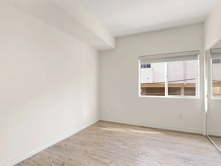 Bedroom with Mirrored Closet and Window