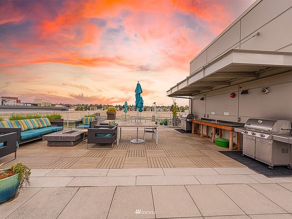 Indoor-outdoor living continues on the community rooftop deck with 360-degree views! Double barbecue, fire pit, and grassy pet area.>