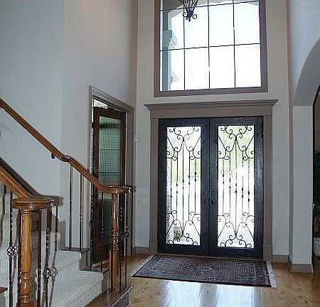 2 story Entry with hardwood floors and a wall of windows