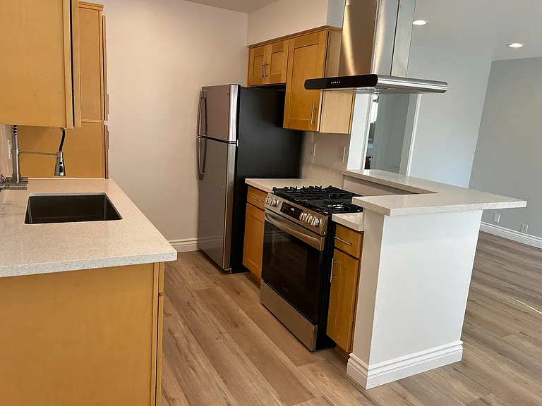 Brand new designer kitchen including refrigerator, stove and hood