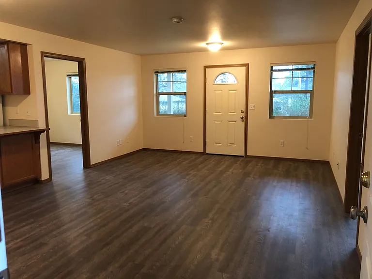 front door opens to living area
featuring brand new flooring
