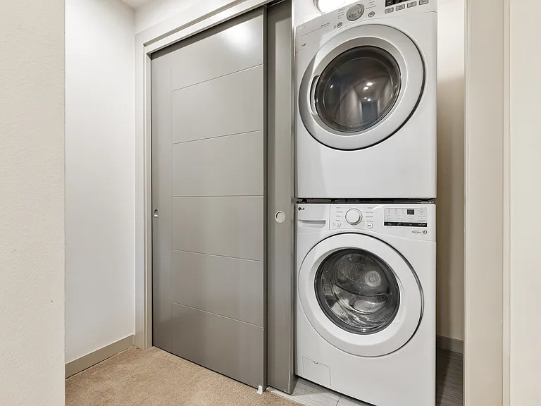 Full sized stackable washer and dryer on top floor.