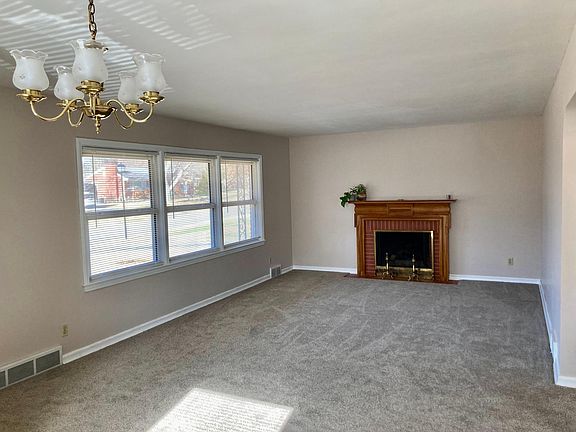Living room has decorative fireplace and plenty of of natural light