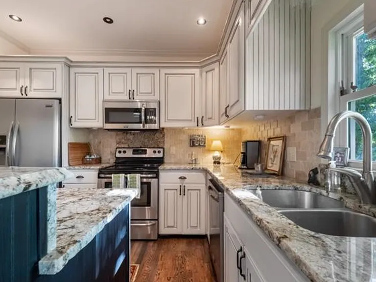 The kitchen is on the entry level, with bar-height seating for two and a pantry. All appliances, including the refrigerator, stay.