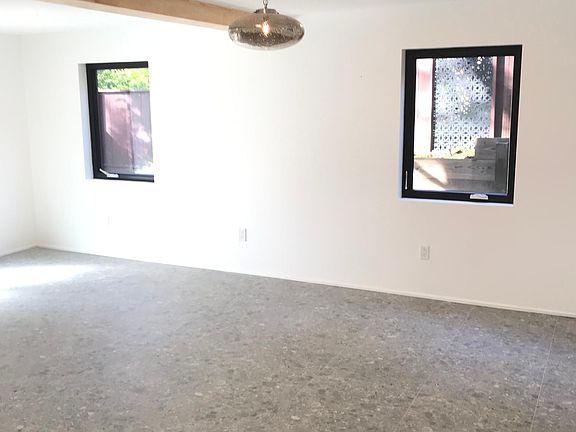 Downstairs large master bedroom with custom tile flooring & lovely casement windows looking out into the private garden area. French doors from the bedroom lead you out unto stone patio & enclosed garden.