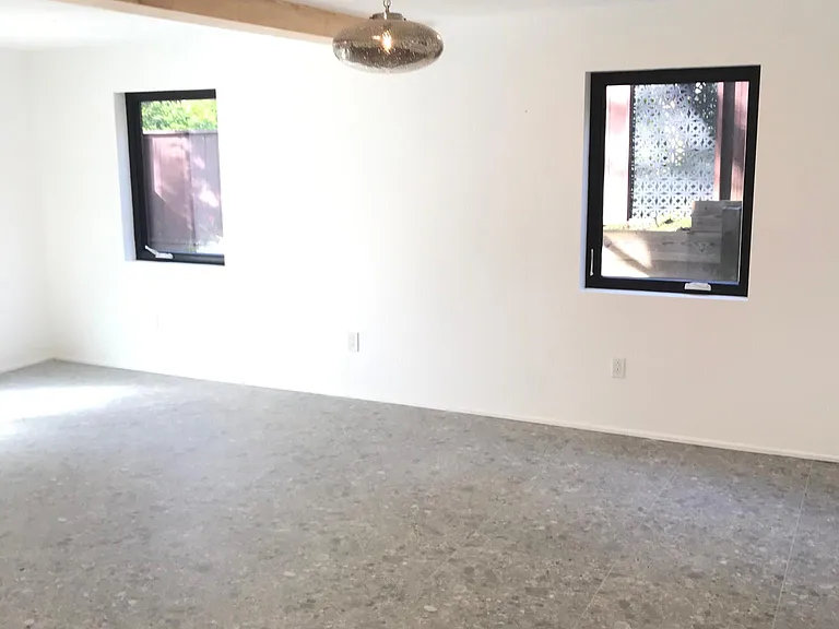 Downstairs large master bedroom with custom tile flooring & lovely casement windows looking out into the private garden area. French doors from the bedroom lead you out unto stone patio & enclosed garden.