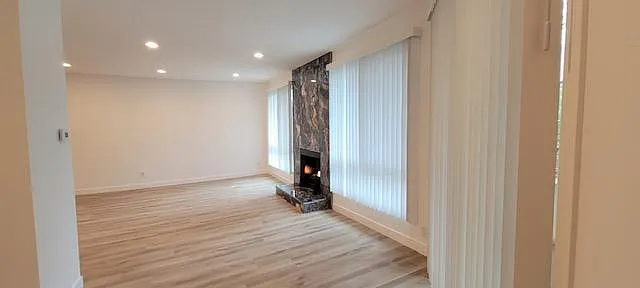 Living room, wood flooring, huge windows, bright and cheery with amazing marble fireplace