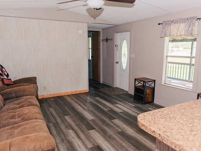 Living room, viewed from kitchen, white door is front door that leads to front deck