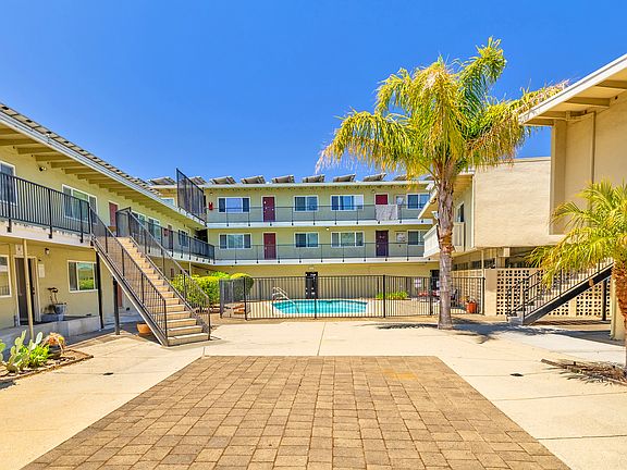 Inviting courtyard-style community featuring tropical landscaping and a bright, welcoming atmosphere