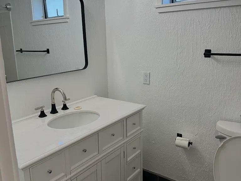 bathroom with large vanity for storage and black fixtures