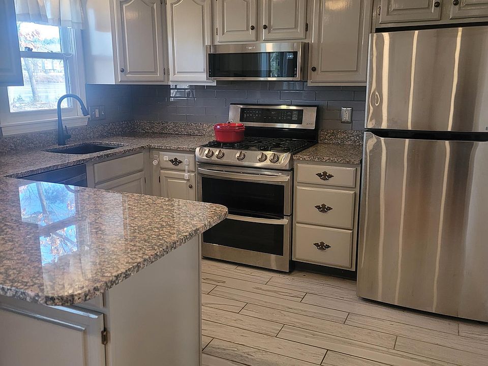 Microwave, gas stove, glass subway tile backsplash, smart faucet, fan, all stainless appliances & granite counter. Breakfast bar is heart of home.
