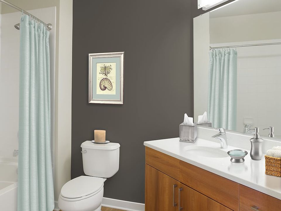 Upgraded bath with walnut cabinetry, white quartz countertop and hard surface flooring