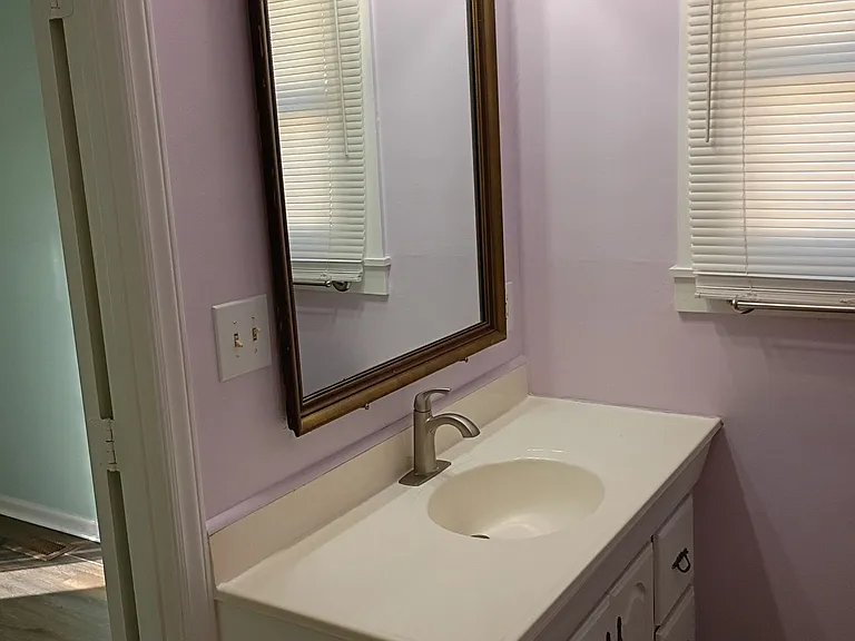 Chic bathroom with a large vanity mirror and soft, calming tones.