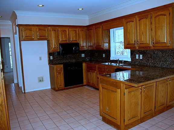 The kitchen has granite countertops and tile floors.