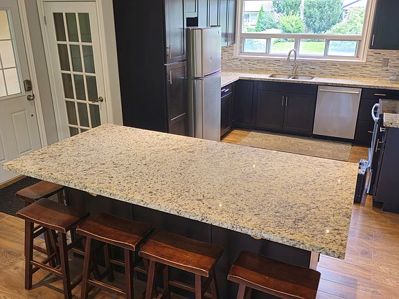 Open concept kitchen with granite countertops and large island with seating for 6 people.