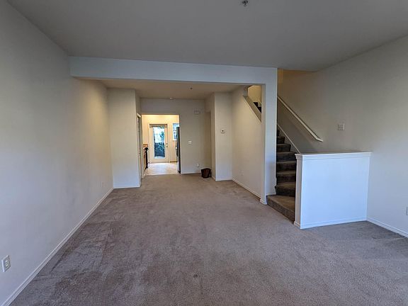 view from living room toward kitchen and stairs to 3rd level