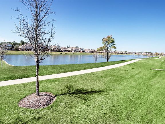 Beautiful view from the back fence of the property. Sidewalk goes all the way around the lake making for a nice morning or evening stroll.