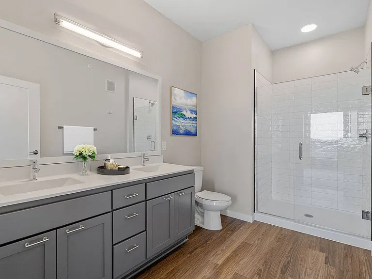 Roomy modern bathroom with spa shower and double sinks at The Hallon Luxury Apartments in Hopkins MN