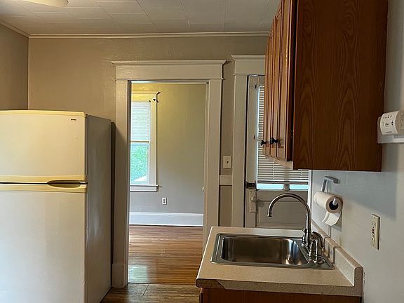 Kitchen looking into bedroom and back entrance.