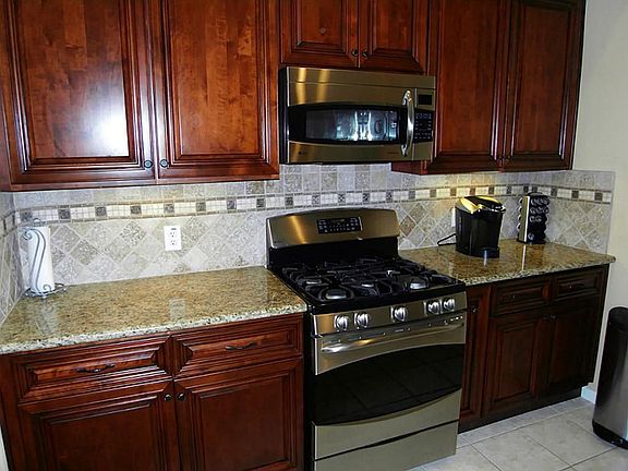KITCHEN WITH GRANITE AND STAINLESS MICROWAVE GAS RANGE