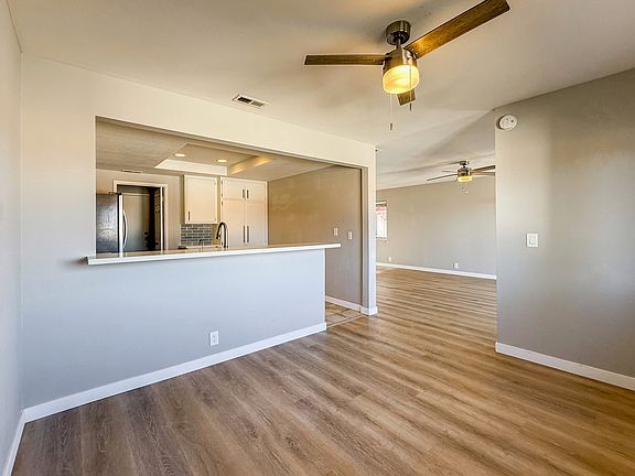 The dining space offers plenty of space, light from the window, an ceiling light with fan