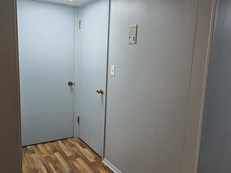 Looking back to entry door, intercom and coat closet