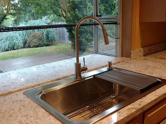 Brand new kitchen sink and faucet in front of huge picturesq
