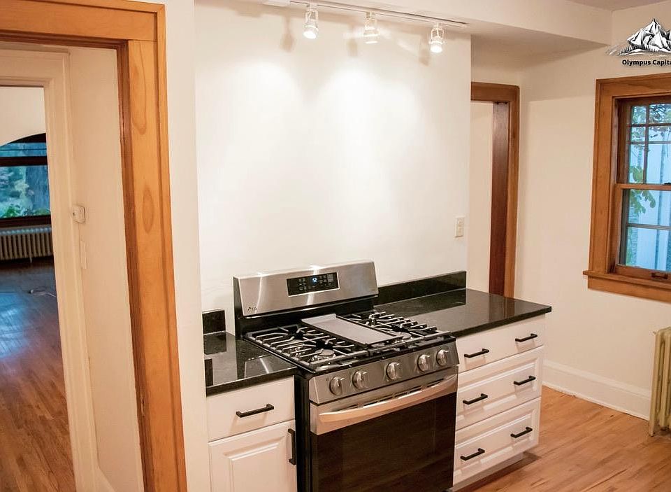 Newly renovated kitchen with brand new stove and cabinets and granite countertops. Gas stove with center hot plate.