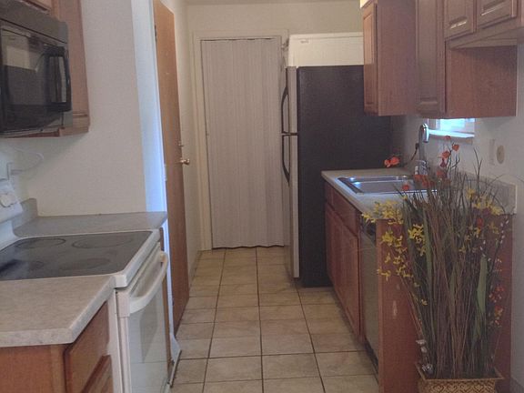 Galley kitchen with washer and dryer at far end right.