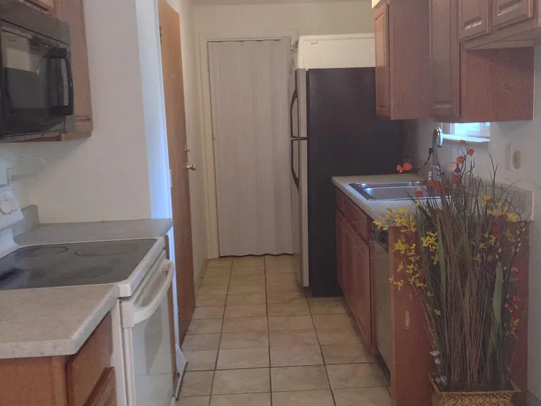Galley kitchen with washer and dryer at far end right.